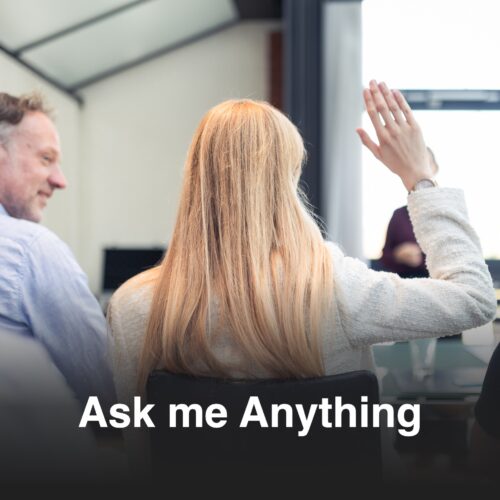 Teilnehmerin einer beruflichen Weiterbildung hebt die Hand während einer interaktiven Ask-Me-Anything-Session